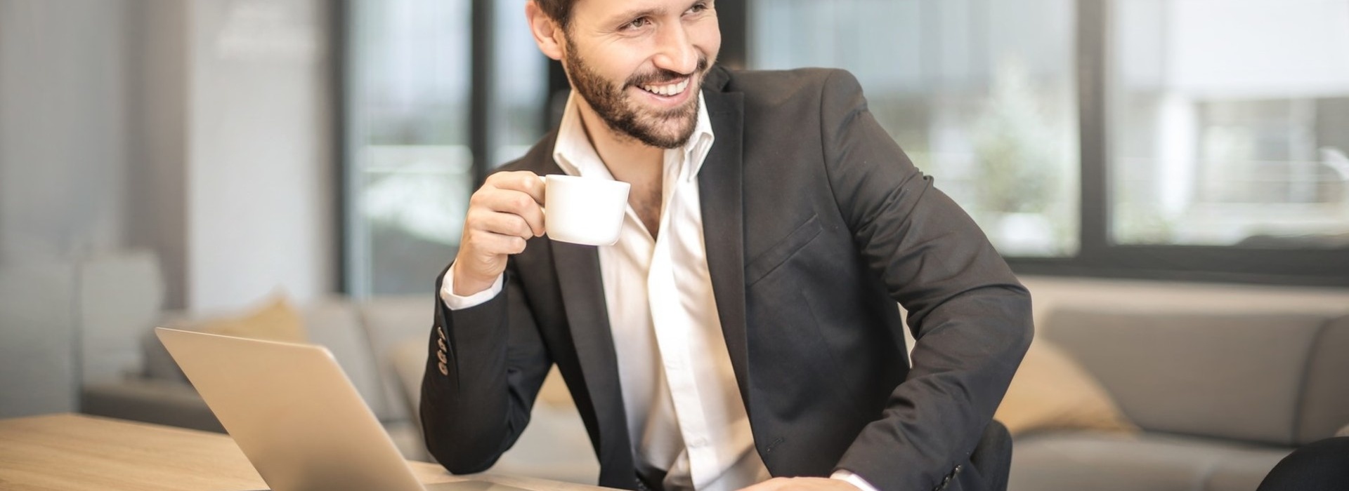 Clanki/man-holding-white-teacup-in-front-of-gray-laptop-842567